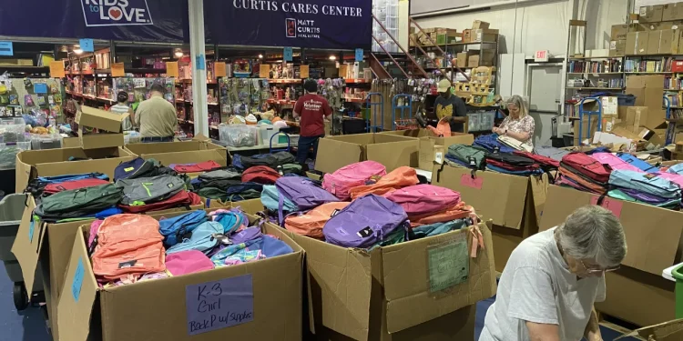 Kids to Love volunteers pack thousands of backpacks for foster care drive